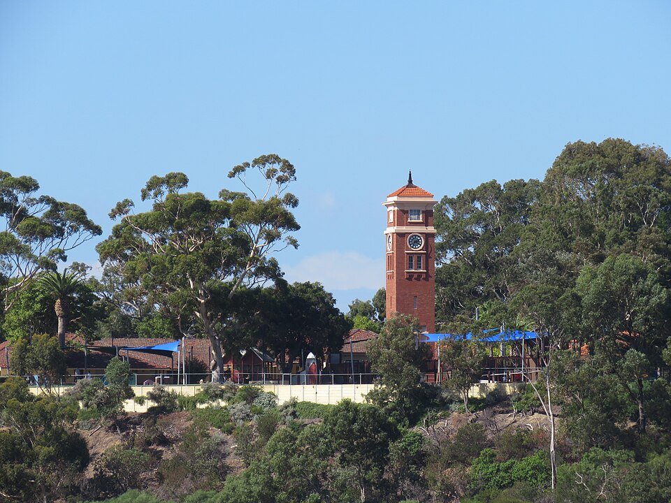 Goolugatup Heathcote clock tower on a green riverside hillside.