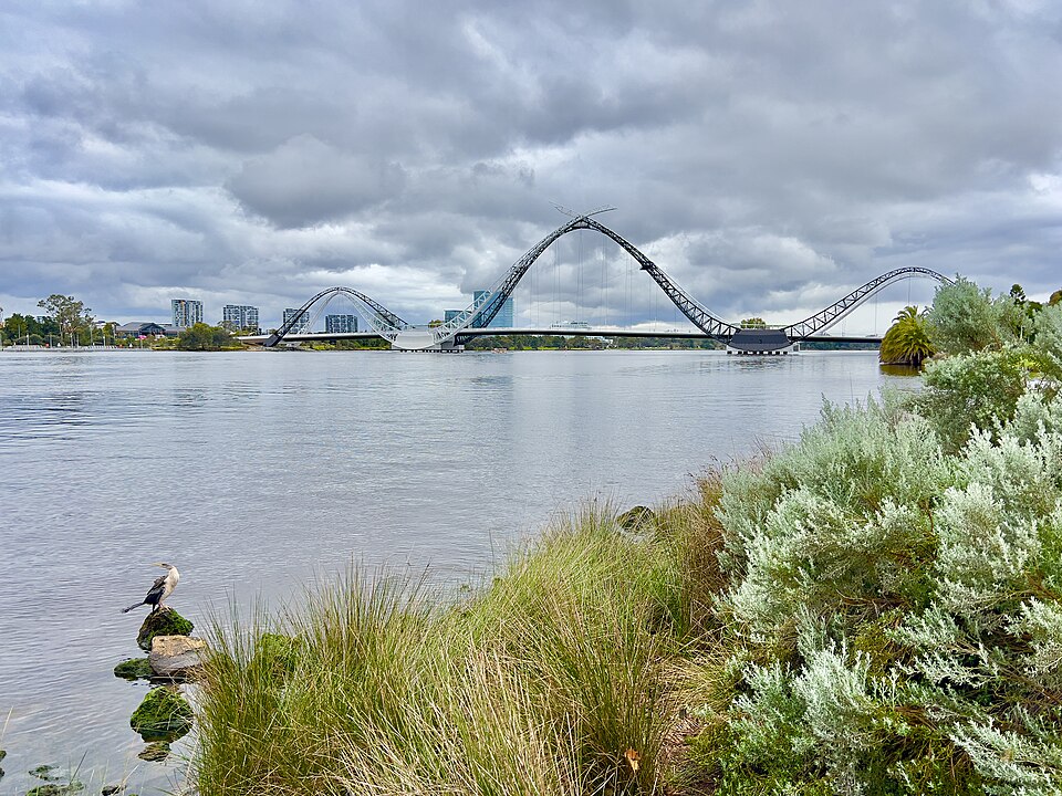 Curved arches of Matagarup Bridge seen across the river