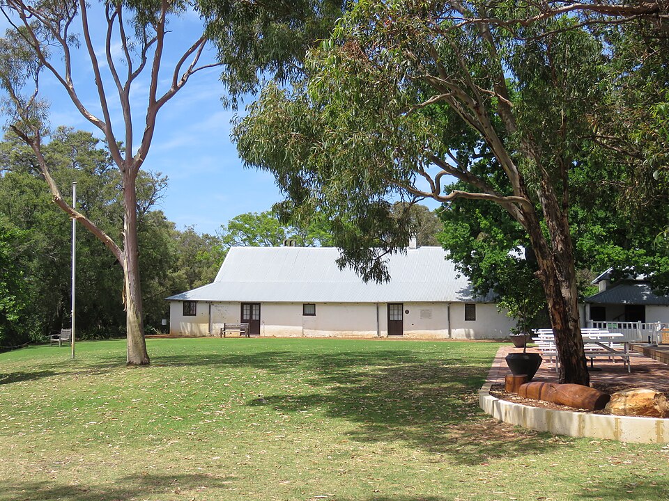 White heritage cottage among trees and lawns at Peninsula Farm.