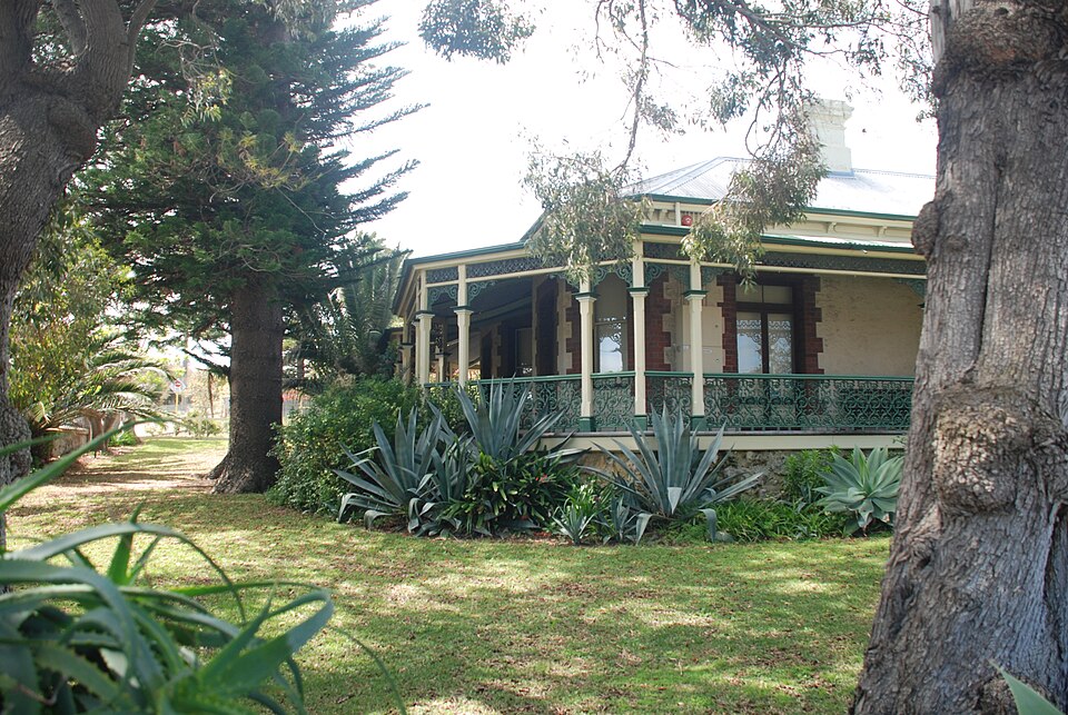 Samson House verandah seen through trees from the garden.